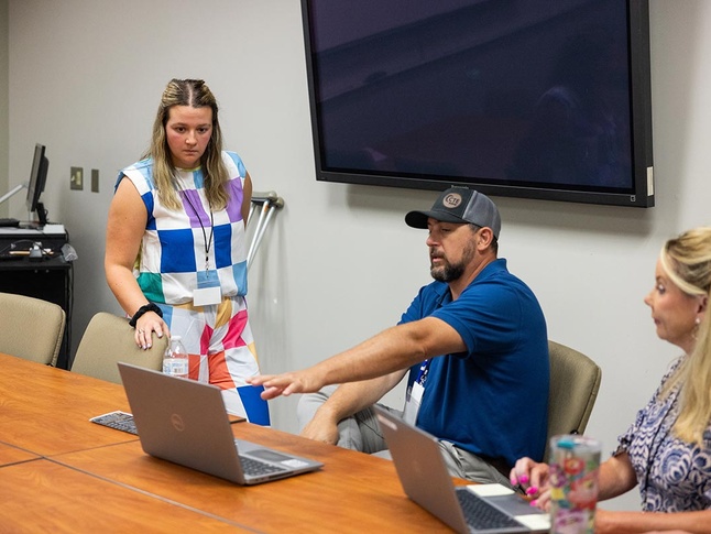 Instructor helping attendee with laptop